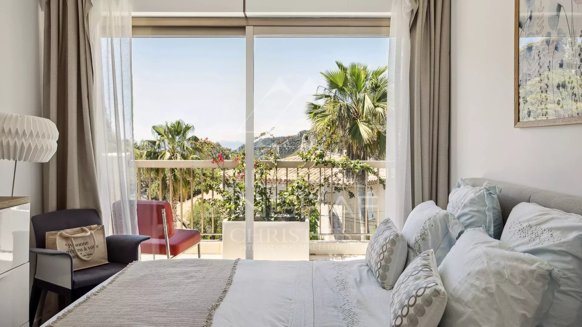 Chambre avec vue à Èze Chambre d'un appartement à Èze avec vue sur la mer et des palmiers à l'extérieur.
