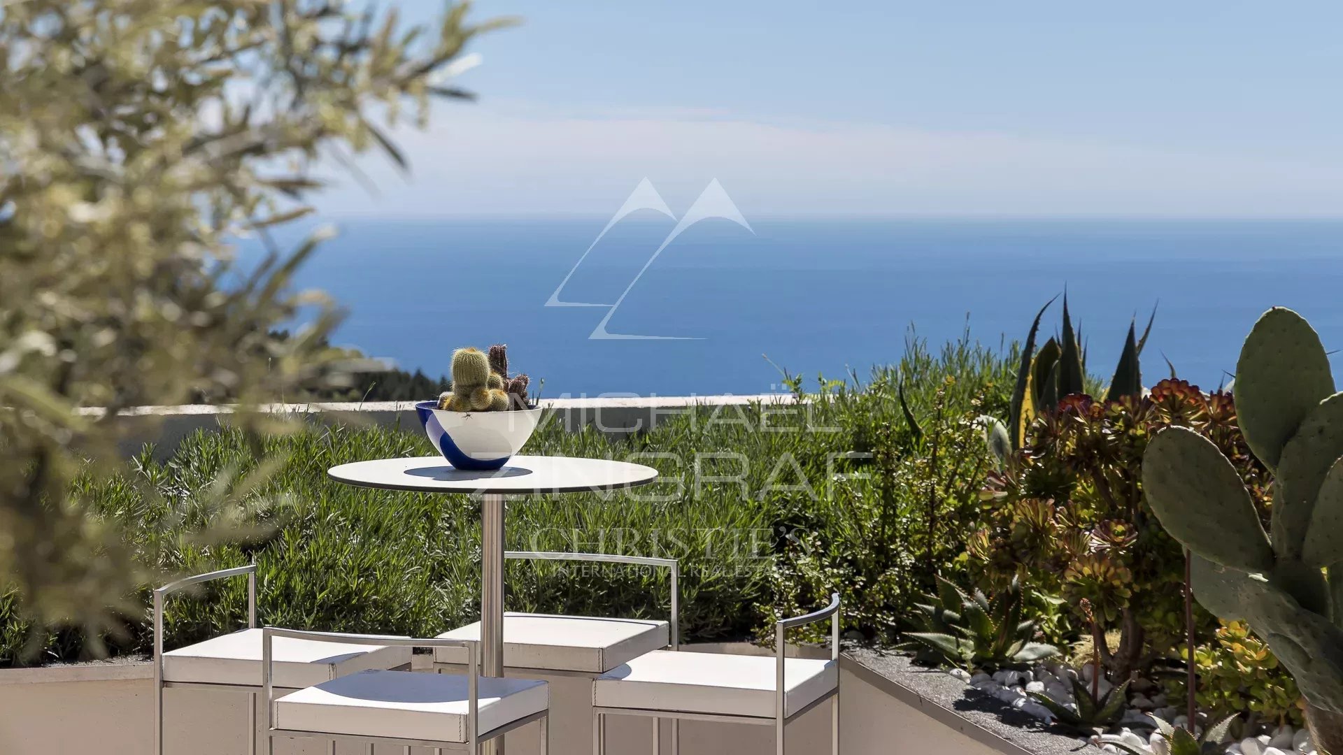 Terrasse avec vue à Èze Terrasse d'un appartement à Èze avec vue sur la mer Méditerranée et des plantes.
