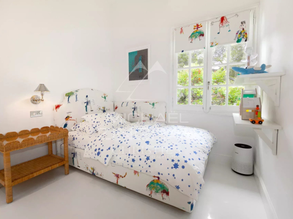 Chambre d'un penthouse rénové à Saint-Jean-Cap-Ferrat avec lit et décor coloré.