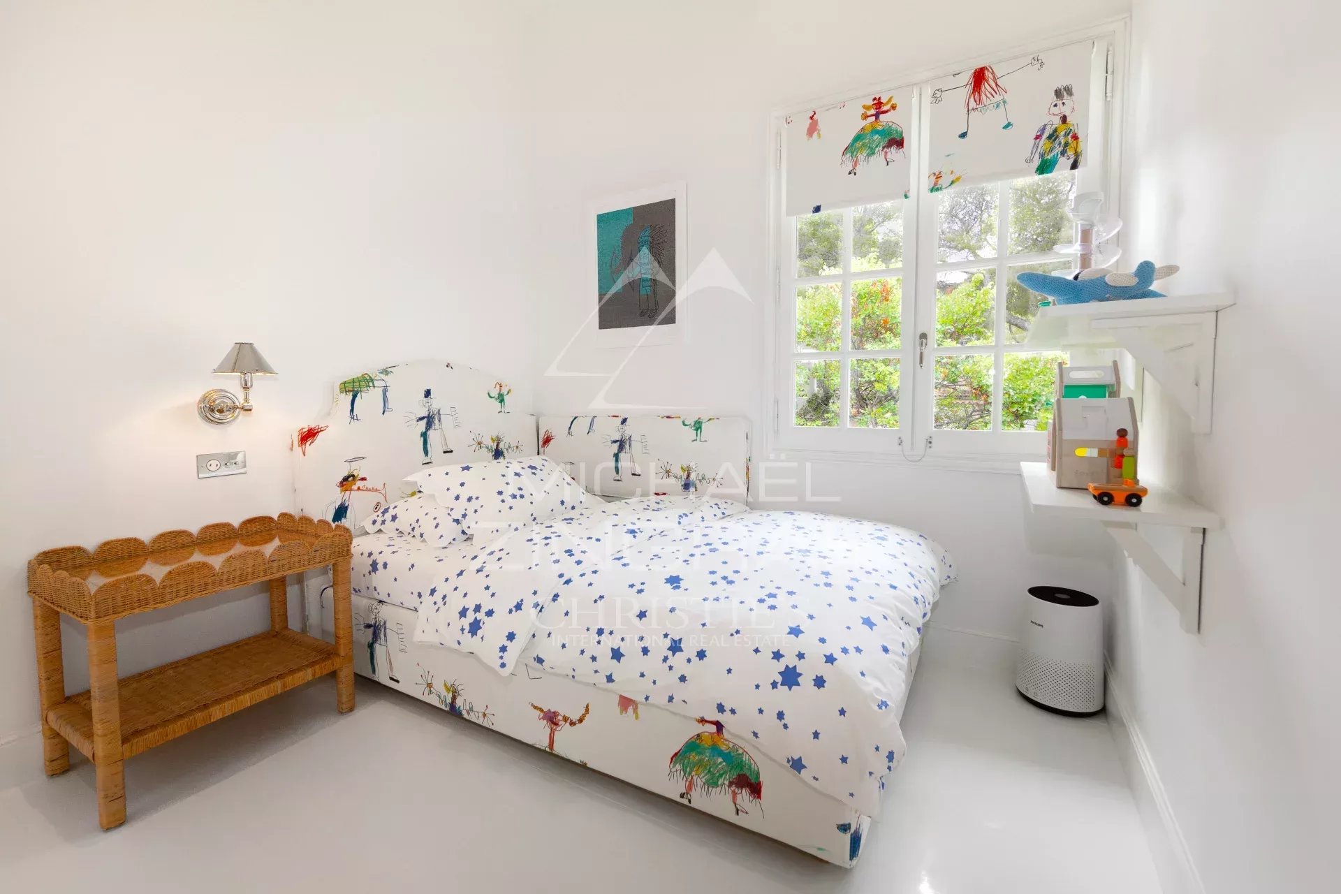Chambre du penthouse à Saint-Jean-Cap-Ferrat Chambre d'un penthouse rénové à Saint-Jean-Cap-Ferrat avec lit et décor coloré.
