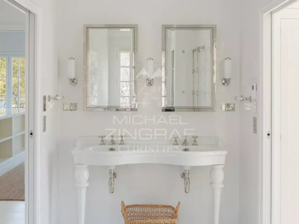 Salle de bain moderne avec deux lavabos et une baignoire, décorée en blanc.