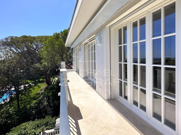Balcon d'un penthouse à Saint-Jean-Cap-Ferrat avec vue sur la mer et la végétation environnante.