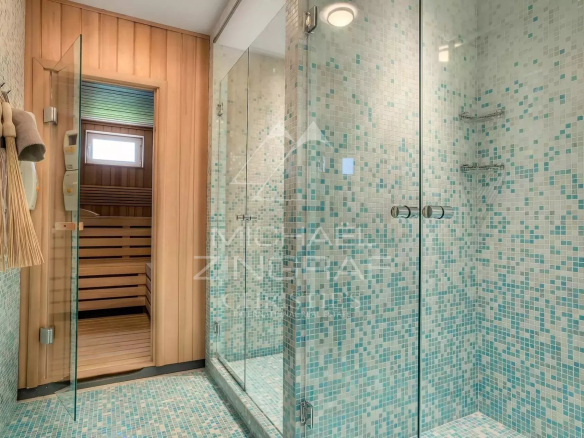 Salle de bain moderne avec douche en verre et sauna en bois.