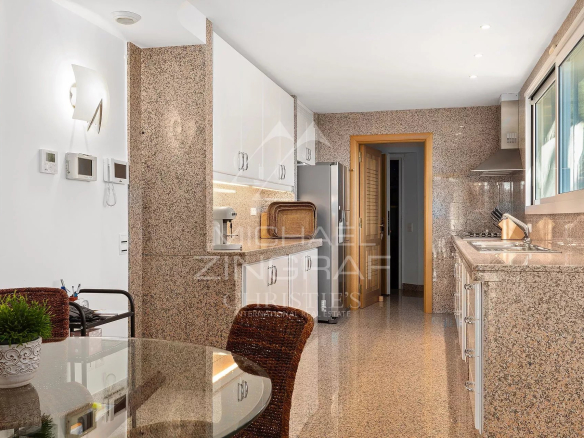 Intérieur d'une villa contemporaine avec cuisine équipée et salle à manger lumineuse.