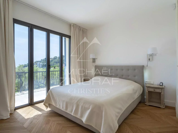 Chambre d'une villa rénovée à Roquebrune-Cap-Martin avec vue sur la nature.