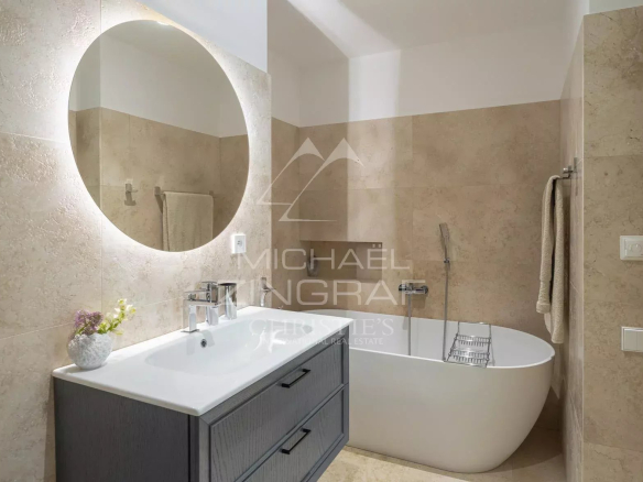 Salle de bain moderne avec baignoire et lavabo dans une villa rénovée à Roquebrune-Cap-Martin.
