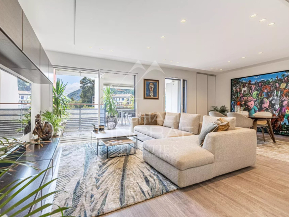 Spacious living room of a modern apartment in Èze with views of the sea and hills.