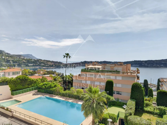 View of a residence with swimming pool in Villefranche-sur-Mer, surrounded by greenery and with a sea view.