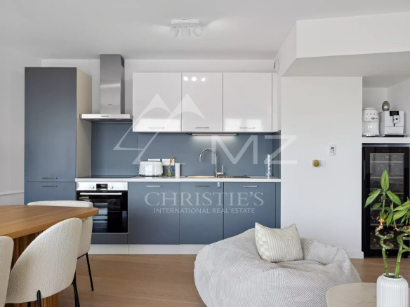 Modern kitchen in an apartment in Beausoleil with contemporary furniture and a view into the living room.