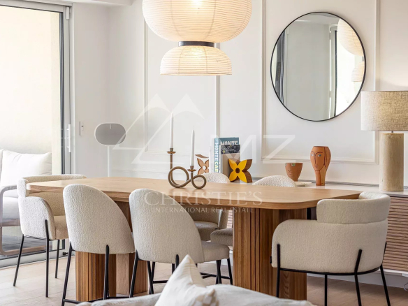 Interior of a modern apartment with a dining table and chairs, elegant decor.