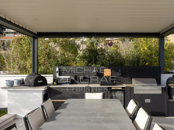 Terrasse avec cuisine extérieure et salle à manger dans un penthouse à Roquebrune-Cap-Martin.