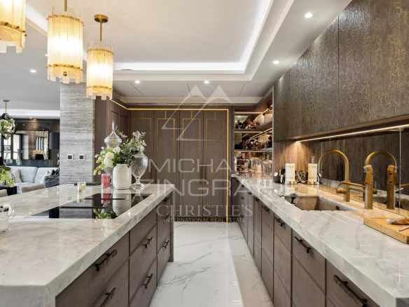 Cuisine moderne avec îlot central et éclairage élégant dans un penthouse à Roquebrune-Cap-Martin.