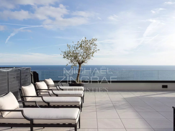 Solarium d'un penthouse avec vue sur la mer à Roquebrune-Cap-Martin, chaises longues et mer en arrière-plan.