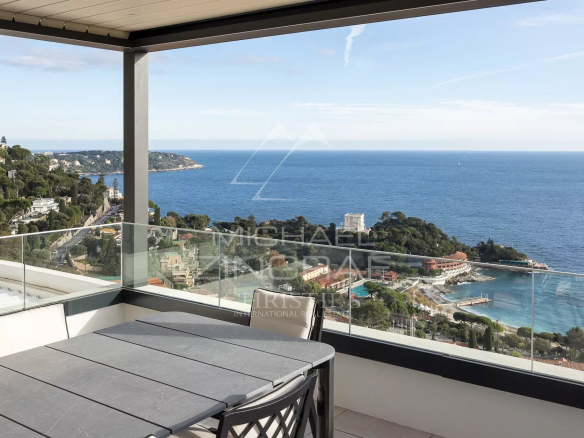 Vue panoramique sur la mer depuis un penthouse à Roquebrune-Cap-Martin, avec mobilier extérieur.