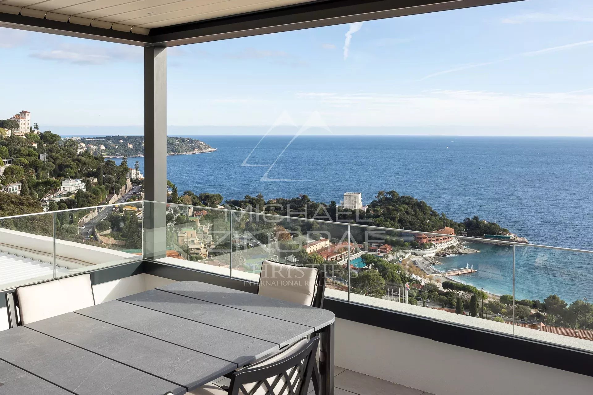 Penthouse avec vue mer à Roquebrune-Cap-Martin Vue panoramique sur la mer depuis un penthouse à Roquebrune-Cap-Martin, avec mobilier extérieur.