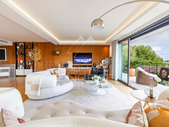 Intérieur d'une villa contemporaine avec vue sur la mer, salon lumineux et mobilier moderne.