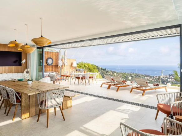 Intérieur d'une villa contemporaine avec vue sur la mer, salon et salle à manger modernes.
