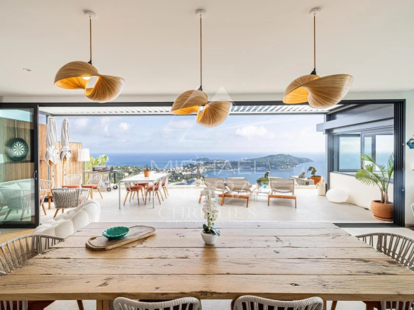 Intérieur d'une villa contemporaine avec vue sur la mer, mobilier moderne et éclairage design.