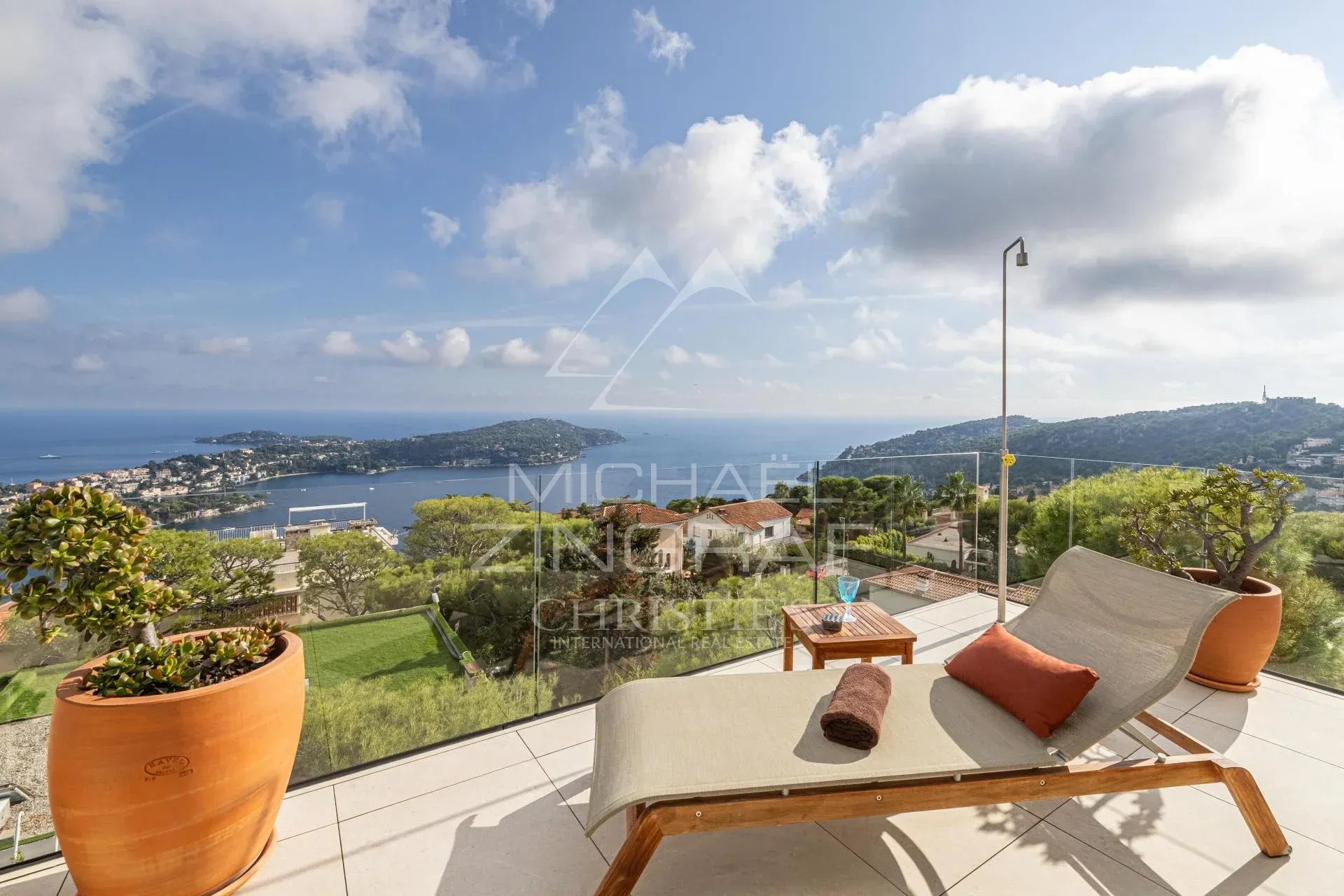 Villa contemporaine avec vue sur la rade Vue panoramique sur la rade de Villefranche-sur-Mer depuis une villa contemporaine avec un transat.