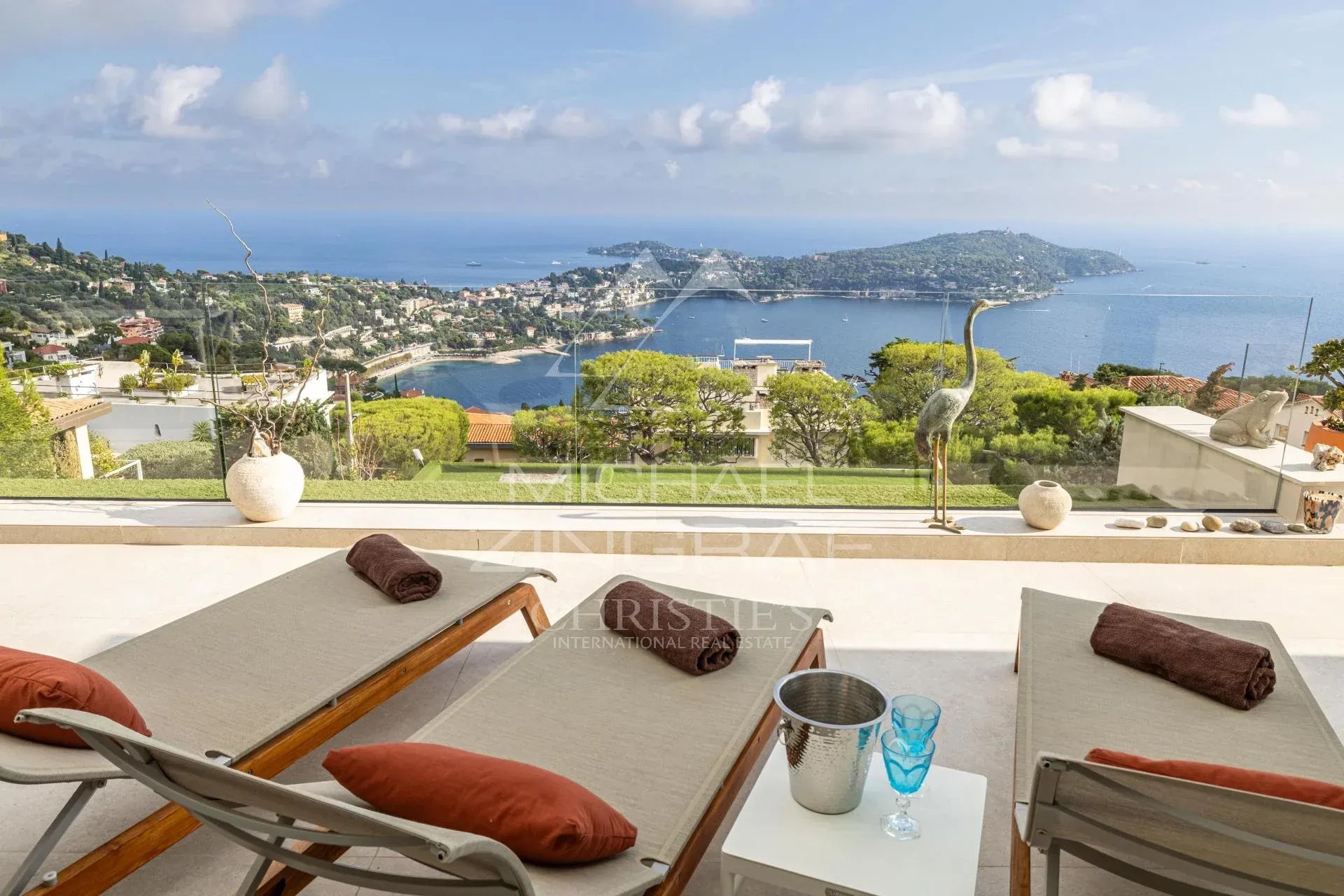 Villa contemporaine avec vue sur la rade Vue panoramique sur la rade de Villefranche-sur-Mer depuis une terrasse avec transats.