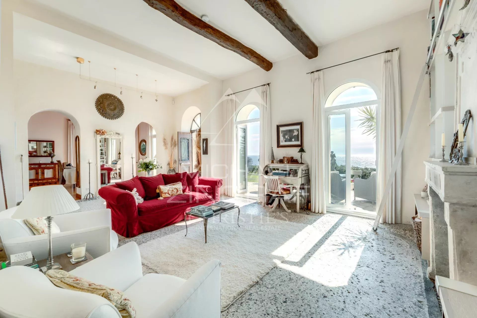Intérieur d’une villa italienne à Èze-sur-Mer Intérieur d'une villa de style italien à Èze-sur-Mer, avec un salon lumineux et des fenêtres donnant sur la mer.
