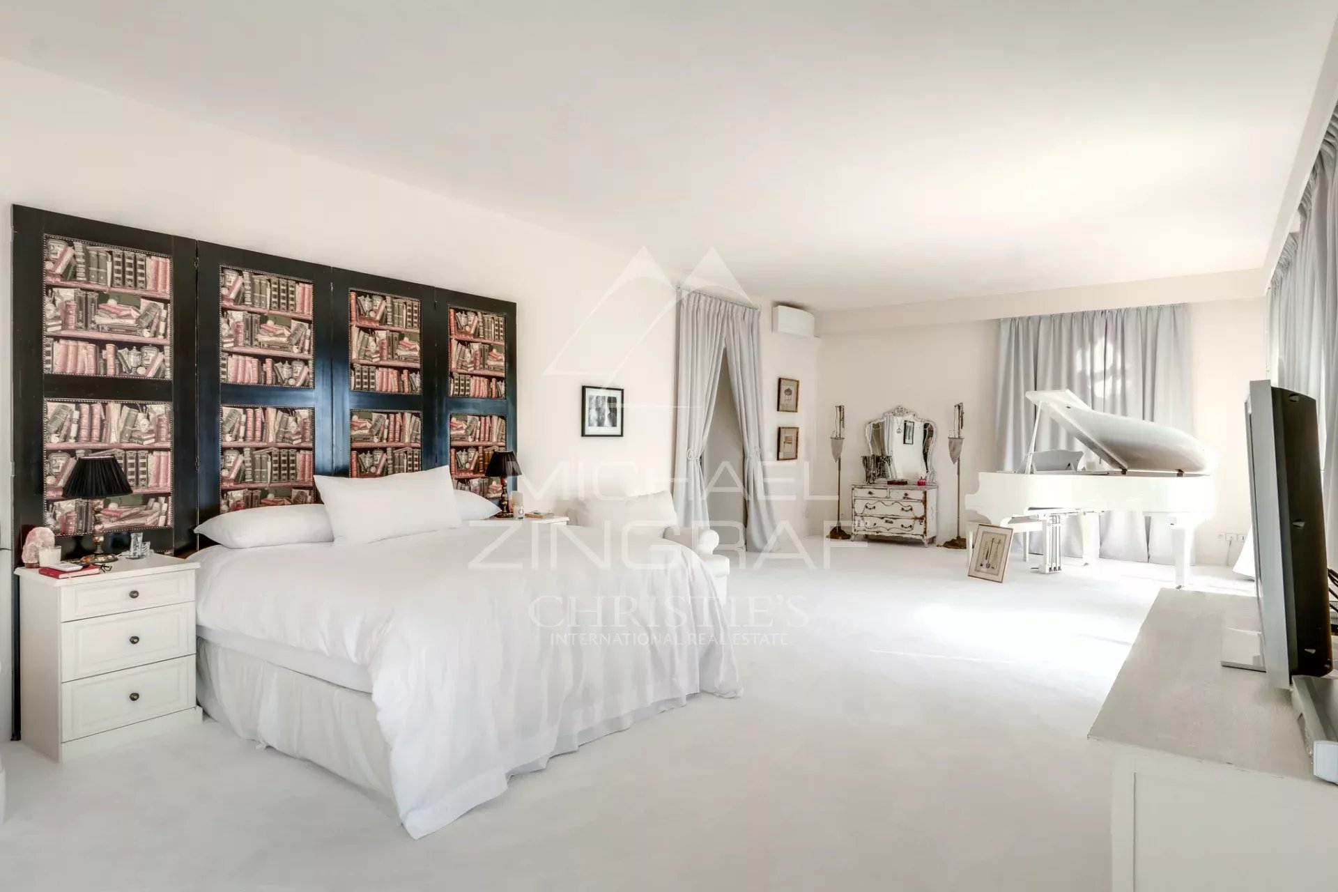 Chambre de villa à Èze-sur-Mer Chambre spacieuse avec lit, bibliothèque murale et piano à Èze-sur-Mer.