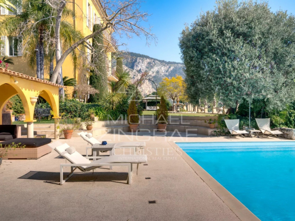 Villa de style italien avec piscine à Èze-sur-Mer, entourée de verdure.