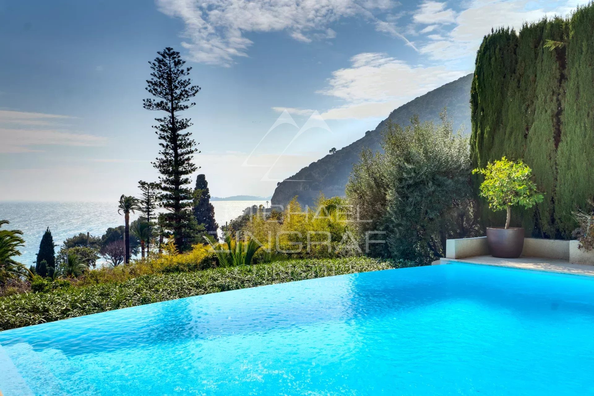 Villa italienne à Èze-sur-Mer Vue d'une villa de style italien avec piscine à débordement et mer en arrière-plan à Èze-sur-Mer.