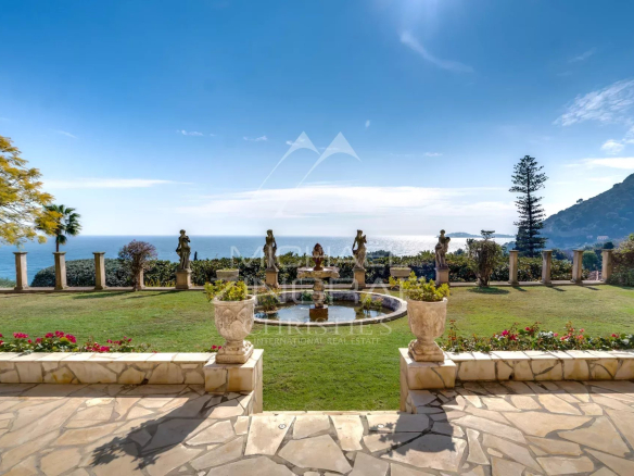Vue depuis une villa de style italien à Èze-sur-Mer, avec jardin et mer en arrière-plan.