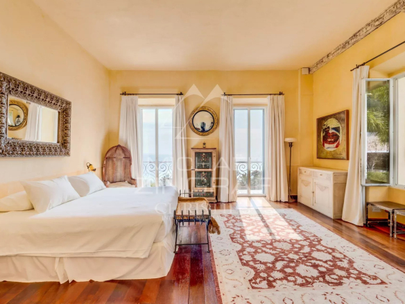 Chambre lumineuse d'une villa italienne à Èze-sur-Mer avec vue sur la mer.