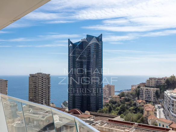 Vue depuis un appartement à Beausoleil avec terrasse et vue mer, immeuble moderne en arrière-plan.