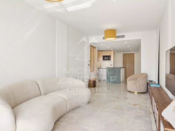 Salon spacieux d'un appartement moderne à Beausoleil avec canapé et télévision.