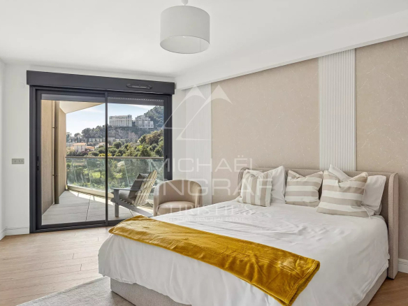 Chambre d'appartement moderne avec balcon à Beausoleil, vue sur la nature environnante.