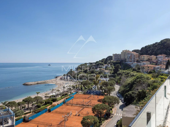 Vue sur la mer et les plages depuis un penthouse à Cap d'Ail, avec des terrains de tennis en premier plan.
