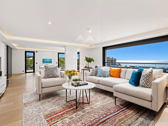 Intérieur d'un penthouse moderne à Cap d’Ail avec vue sur la mer, salon lumineux et mobilier contemporain.