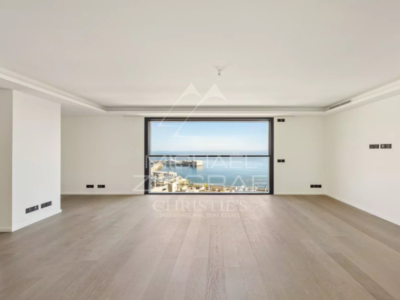 Intérieur d'un penthouse à Cap d'Ail avec vue sur la mer, murs blancs et parquet clair.
