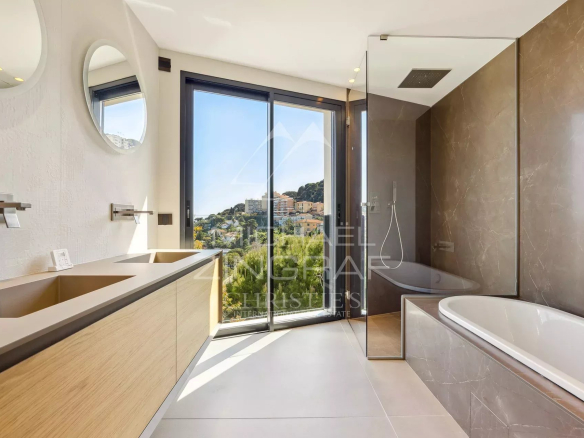 Salle de bains moderne avec baignoire et vue sur la nature à Cap d'Ail.