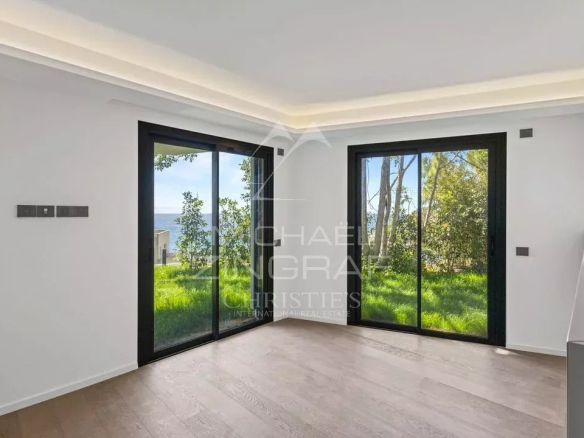Interior of a new apartment in Cap d'Ail with large windows and access to a garden.