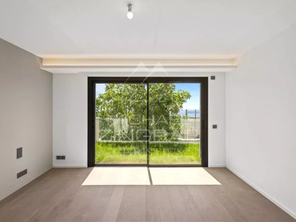 Interior of a new apartment in Cap d'Ail with large bay windows and a view of the garden.