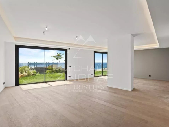 Interior of a new apartment in Cap d'Ail with a large, bright living room and access to a garden.