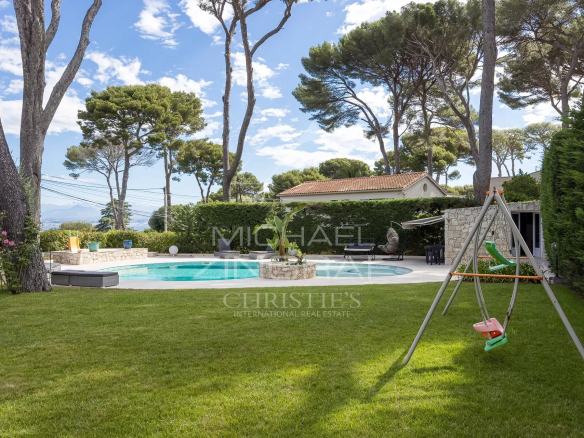 Jardin avec piscine et aire de jeux dans une propriété au Cap d'Antibes.