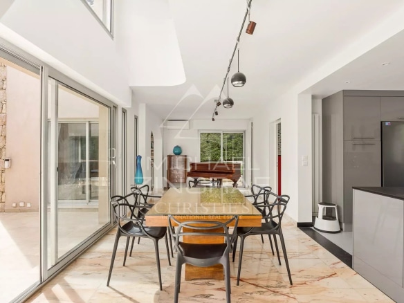 Intérieur d'une villa moderne avec salle à manger et cuisine ouverte au Cap d'Antibes.