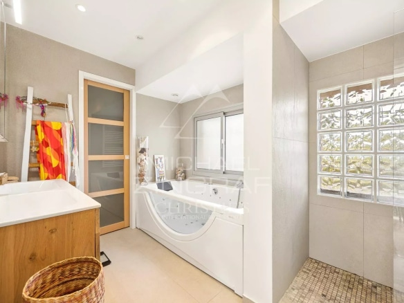 Salle de bain moderne avec baignoire et douche, décorée de manière élégante.