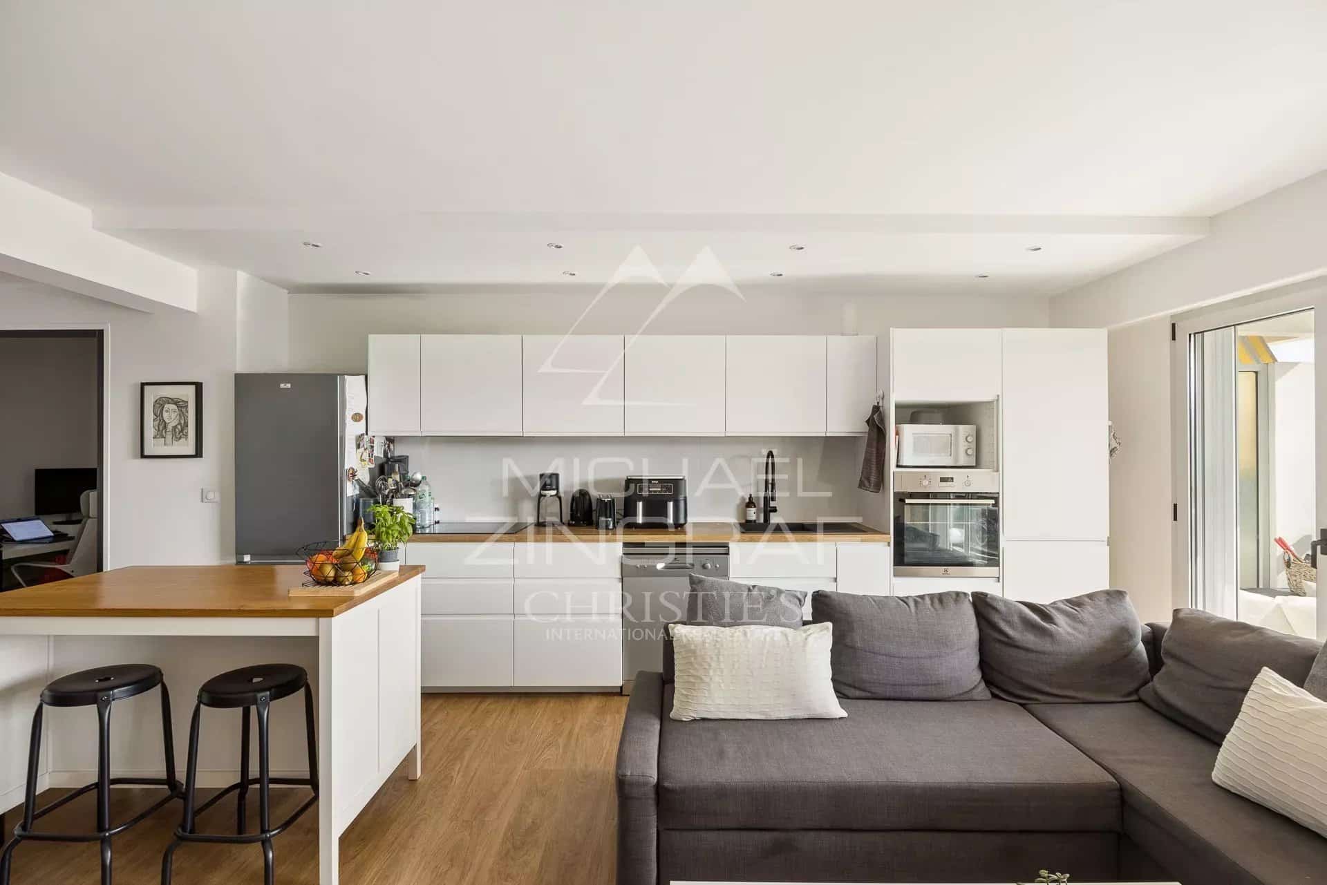 Kitchen and living room of an apartment in Cap d'Antibes Modern kitchen opening onto a living room in an elegant apartment in Cap d'Antibes.