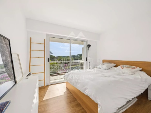 Room in a bright apartment with a double bed and a view of nature.