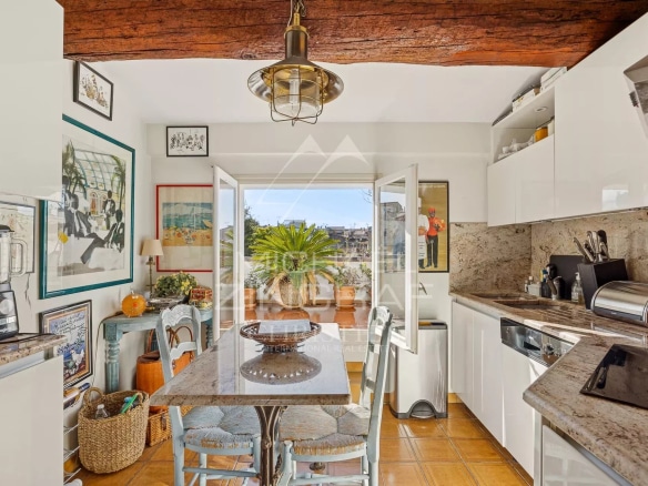 Cuisine moderne avec table à manger et accès à une terrasse, appartement à Antibes.