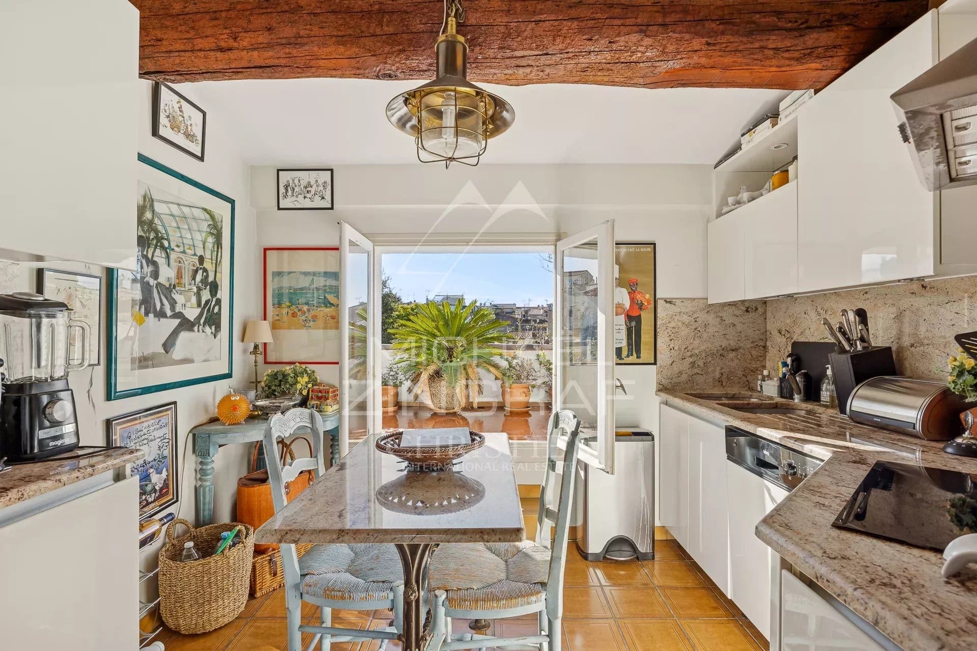 Cuisine moderne avec table à manger et accès à une terrasse, appartement à Antibes.