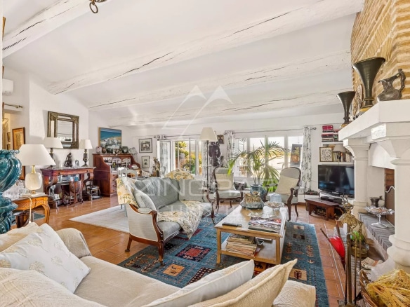 Intérieur d'un appartement spacieux avec salon lumineux et cheminée, décoré avec des meubles variés.