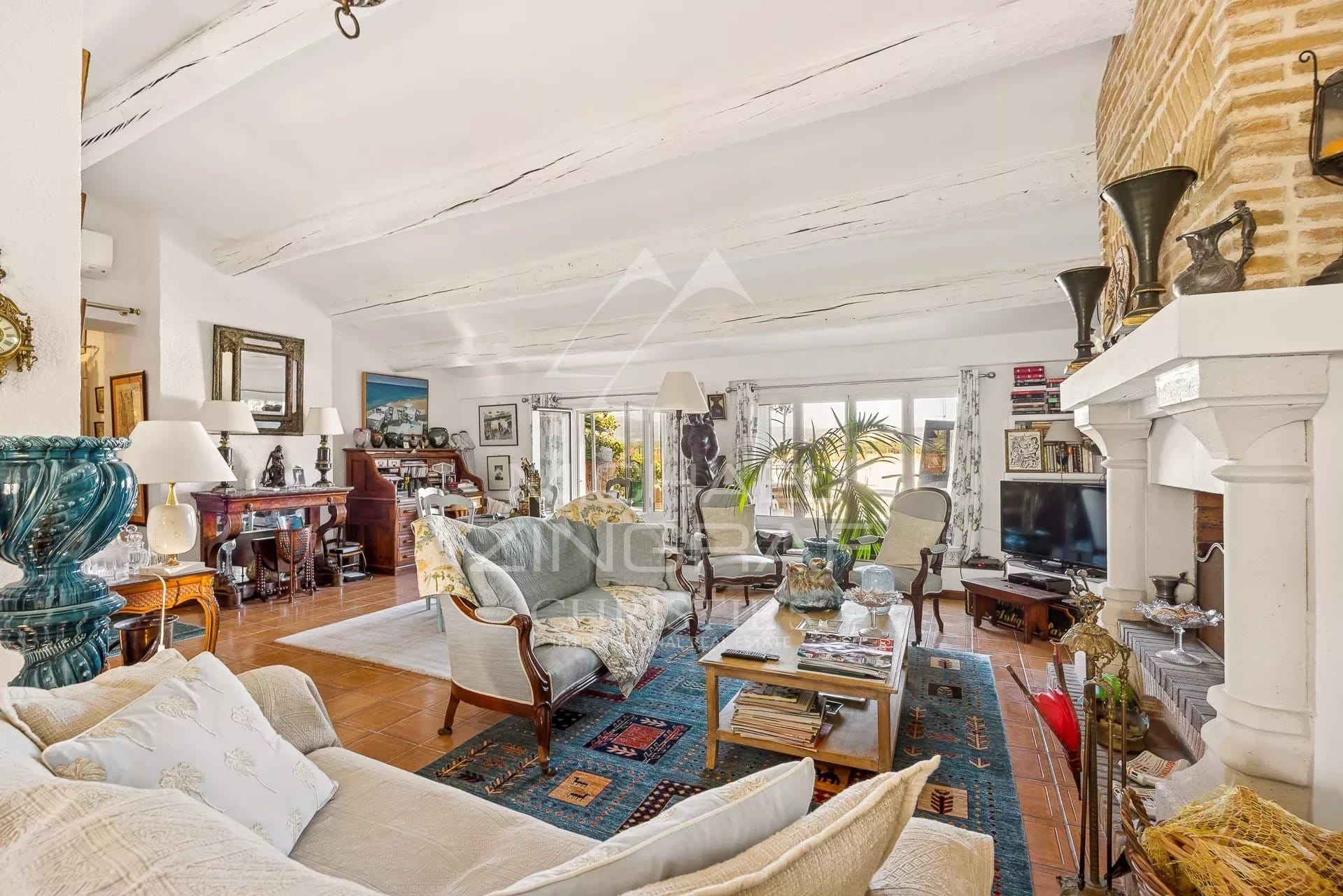 Intérieur d'un appartement spacieux avec salon lumineux et cheminée, décoré avec des meubles variés.