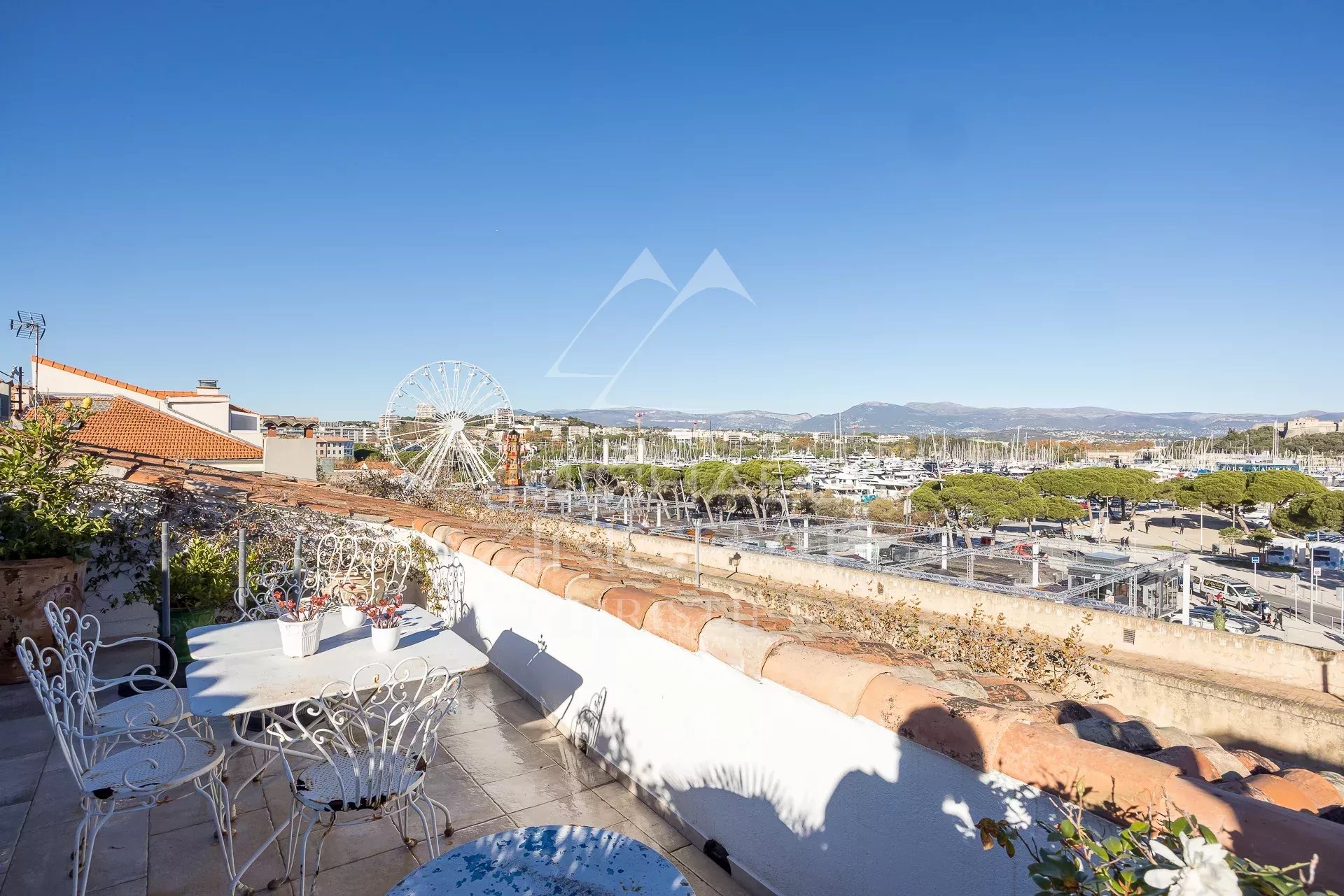 Terrasse d'un appartement avec vue panoramique sur le port d'Antibes et la ville.